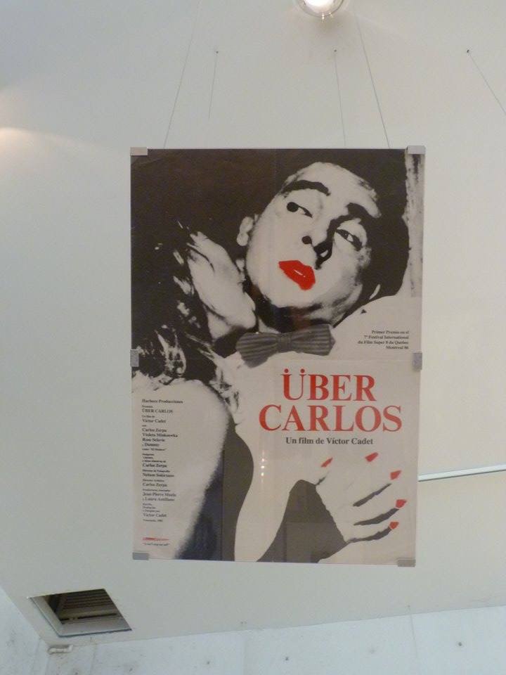 Registro fotográfico del afiche de la película Súper 8 Über Carlos (Sobre Carlos) en muestra sin identificar.