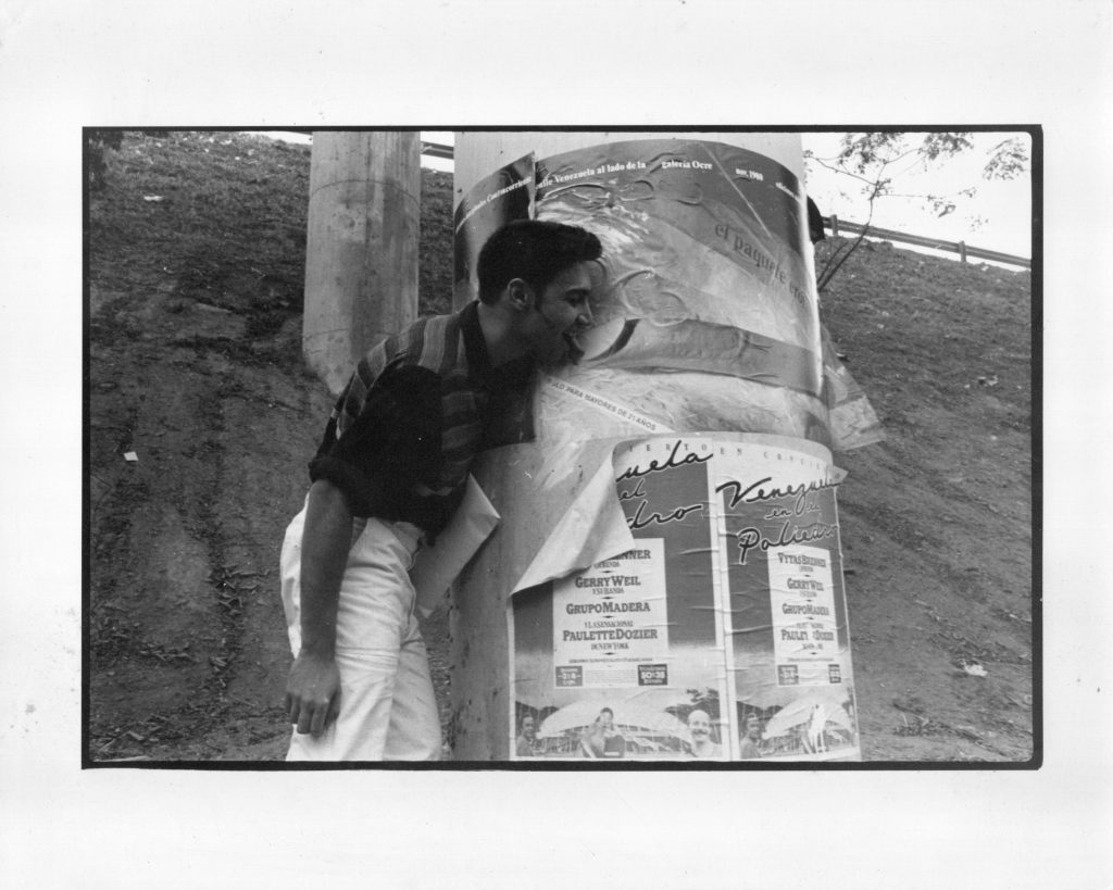 Julio Vengoechea. Marco Antonio Ettedgui posando junto al afiche de la exhibición El paquete erótico, frente a la Sala Ocre, lugar de la muestra. Sabana Grande, Caracas, 1980. Fotografía cortesía de Édgar Carrasco.