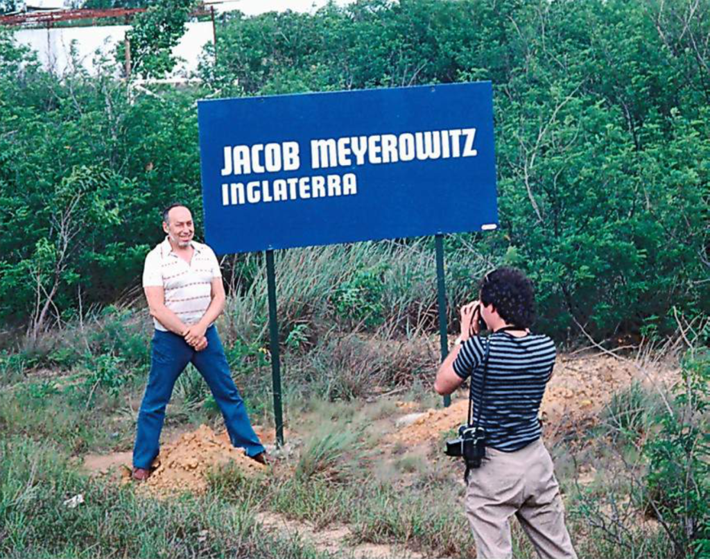 jacob meyerowitz junto a la valla con su nombre y lugar de nacimiento, ubicada unos metros antes que su obra
